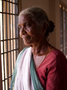 Old Indian woman gazing out of window